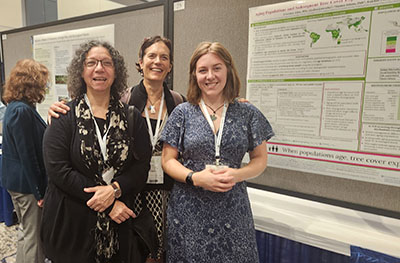 Photo of CIESIN's Susana Adamo, co-author Sara Curran and lead author Courtney Allen next to their Population Association of America poster