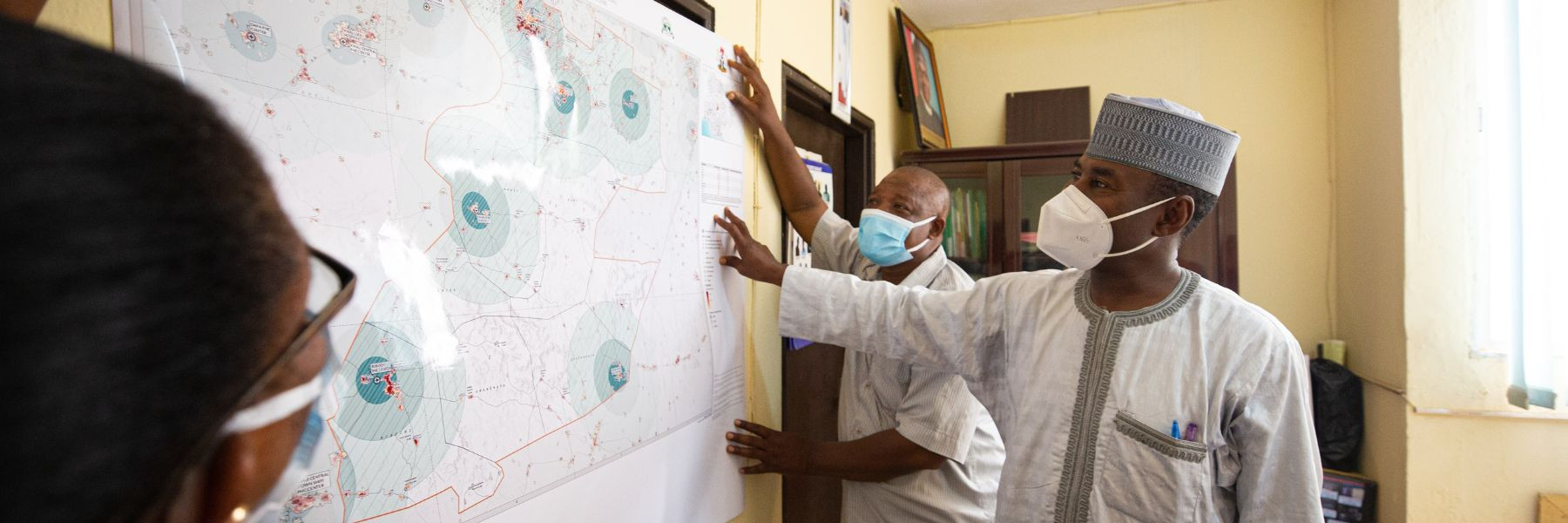 Health officials in Nigeria reviewing GRID3 catchment area maps for COVID-19 vaccinations produced by CIESIN, supporting vaccination microplanning efforts. Image Credit: Leke Alabi-Isama.